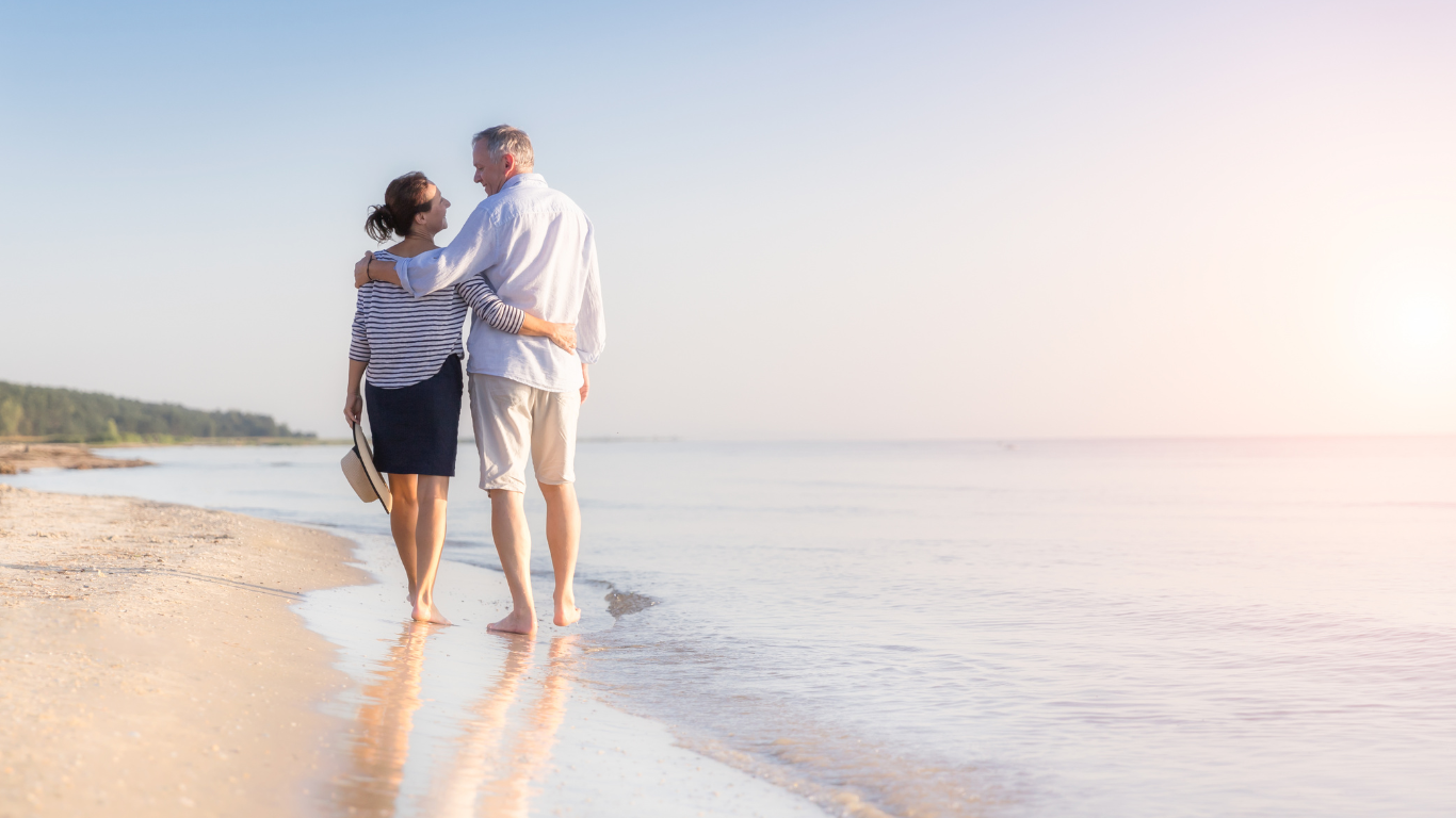 Senior couple walking along beach