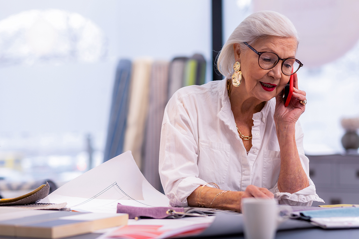A mature woman takes a phone call at her CEO work desk
