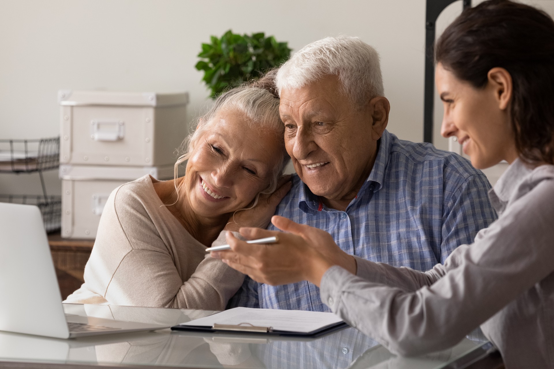 Female moving manager showing floor plans to an excited senior couple