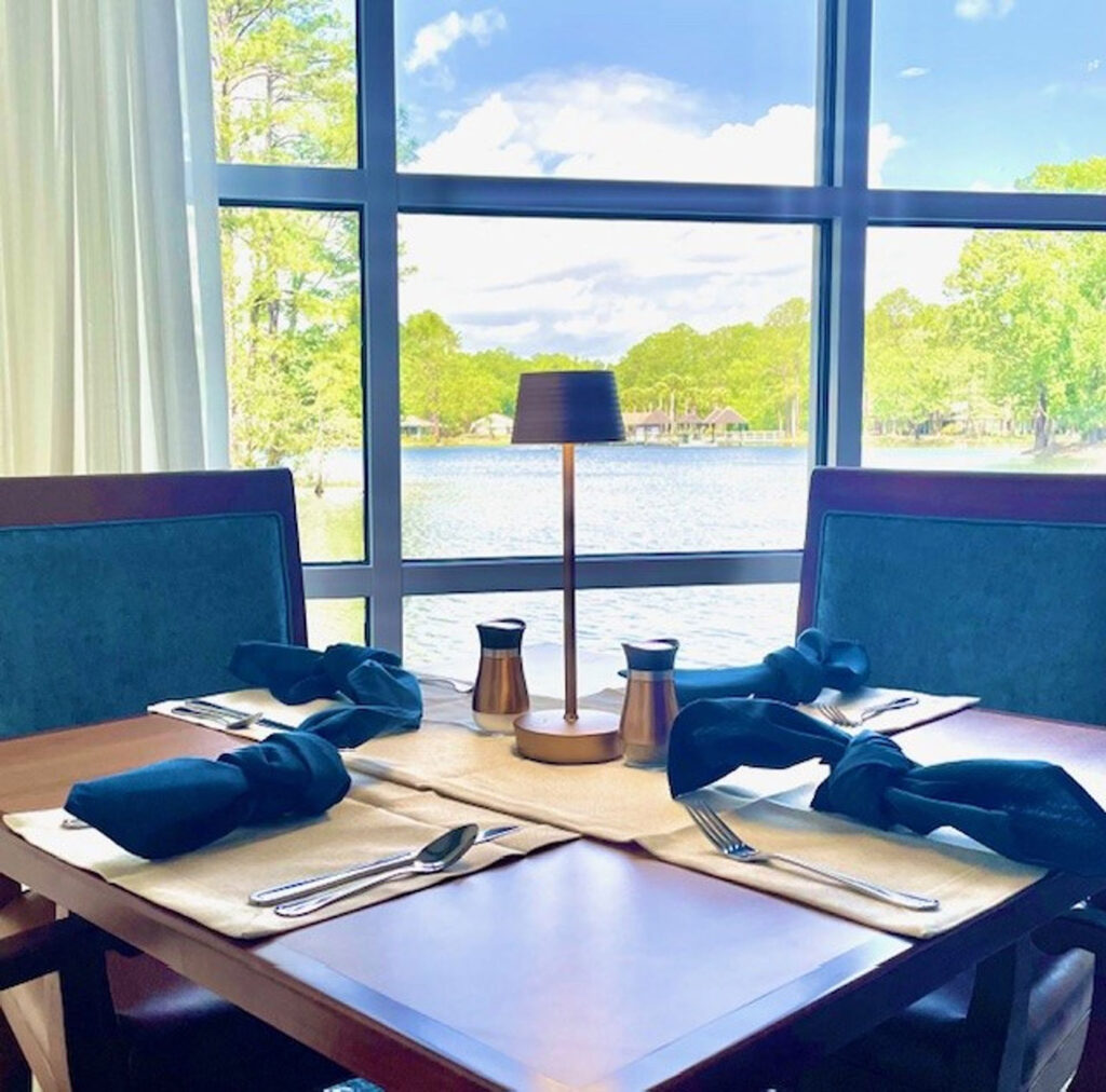 A table in front of a window looking out onto water