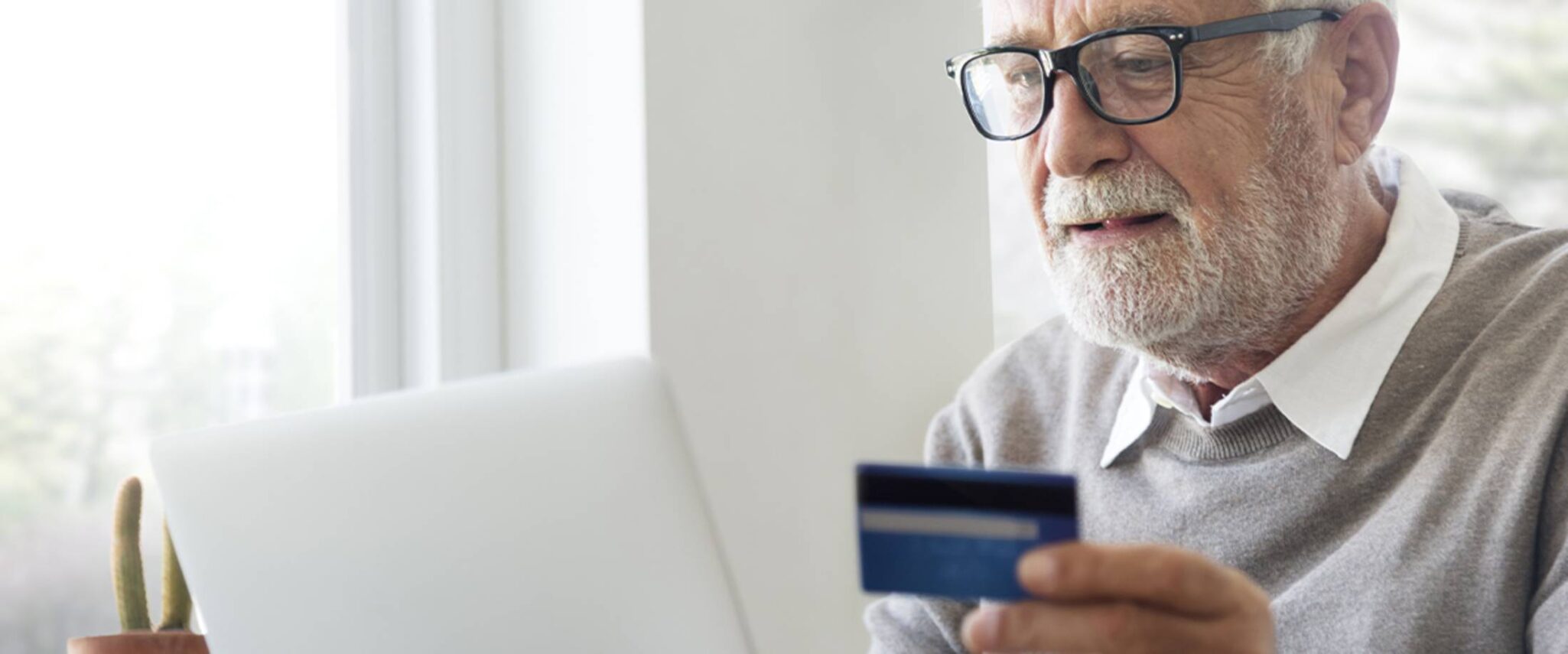 elderly man checking his credit card statement in his senior apartment